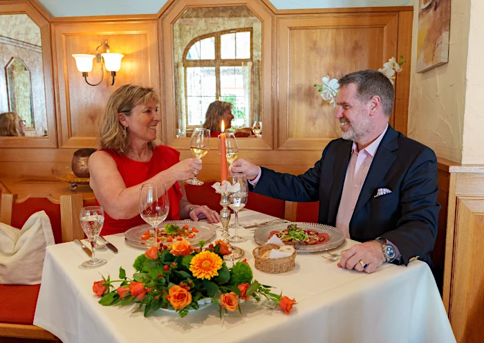 Restaurant Kurhaus-Stuben im Hotel Kurhaus Ochs, ein Paar sitzt am Tisch und stoesst mit Champagnerglaesern an